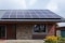 The image shows solar panels on the roof of the house